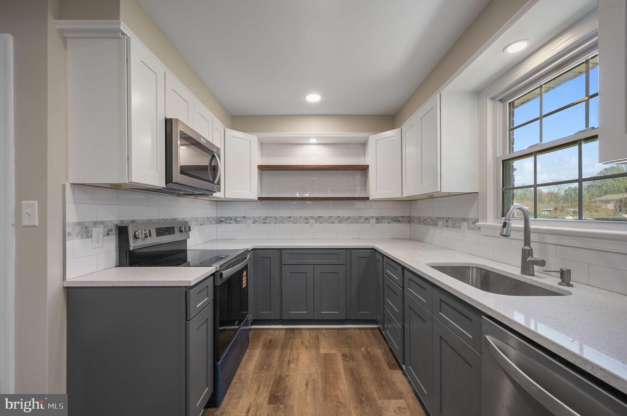 201 North Old Mill Road Dover, DE 19901 - Photo 12 of 27 a kitchen with stainless steel appliances granite countertop a sink stove and microwave