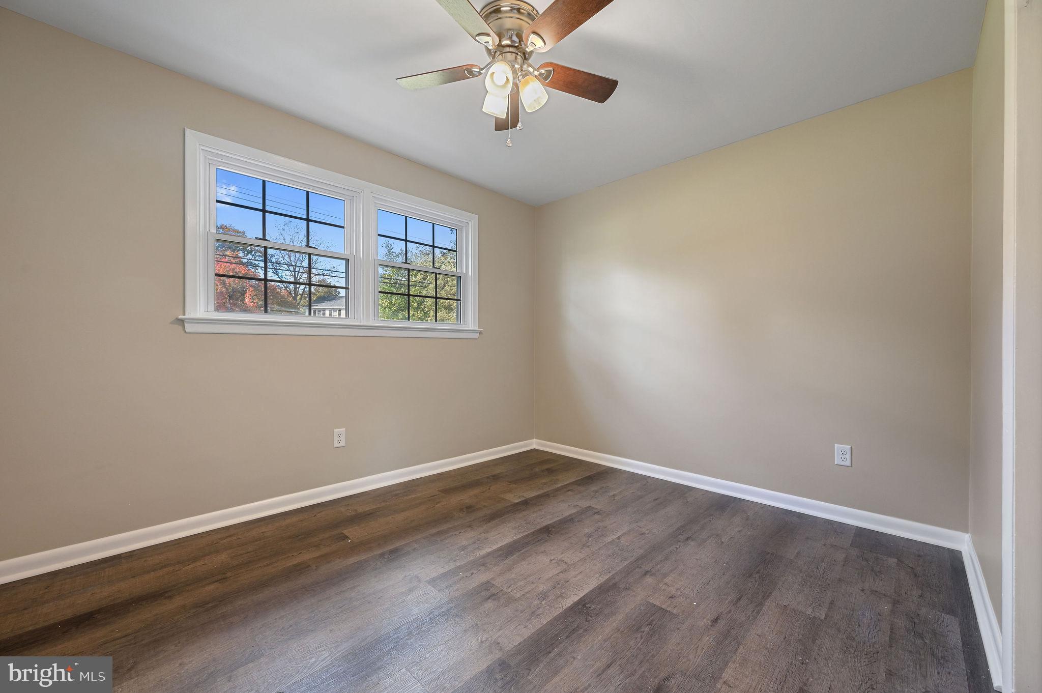201 North Old Mill Road Dover, DE 19901 - Photo 18 of 27 an empty room with wooden floor chandelier fan and windows
