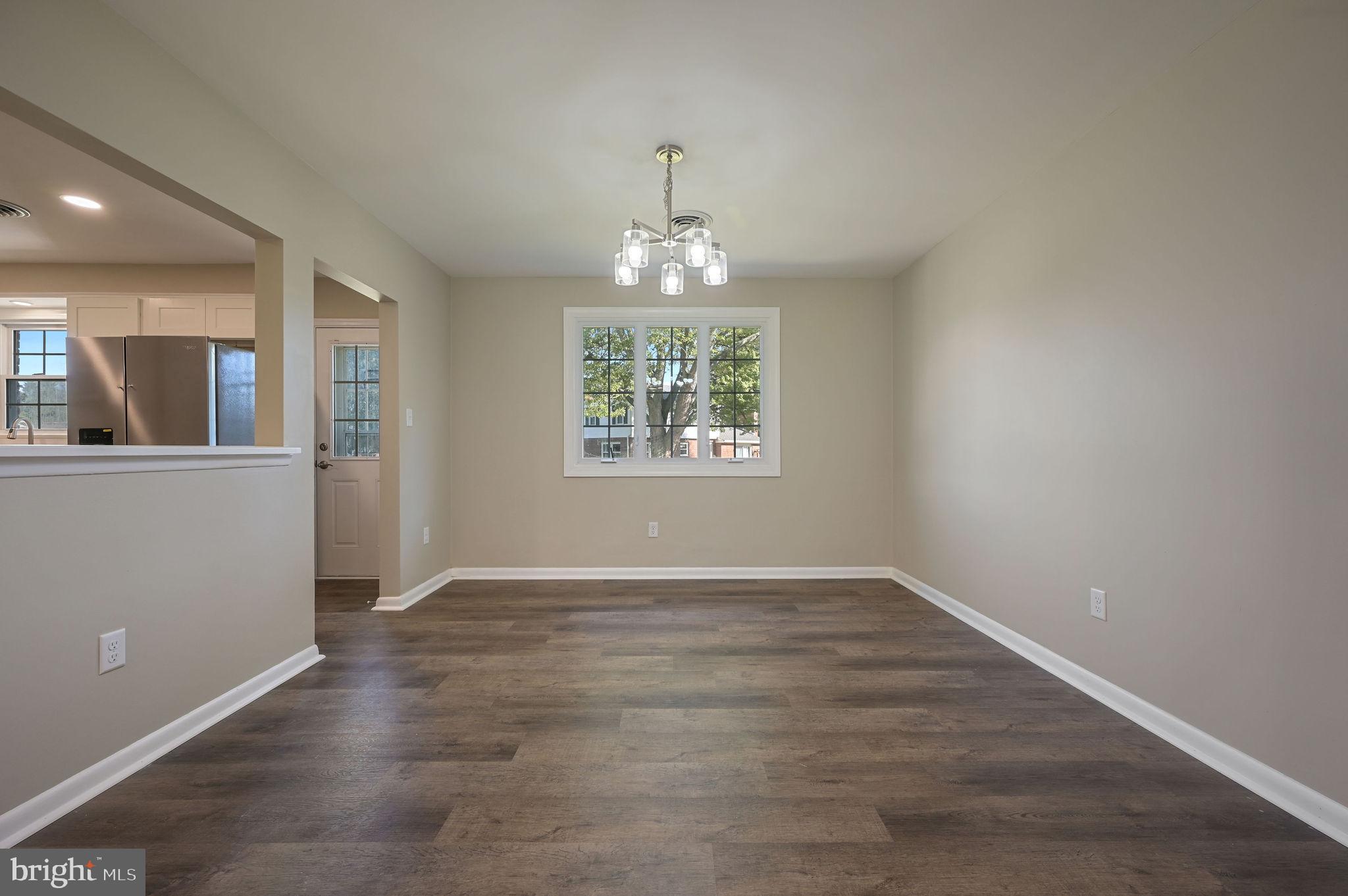 201 North Old Mill Road Dover, DE 19901 - Photo 9 of 27 an empty room with wooden floor a chandelier and windows