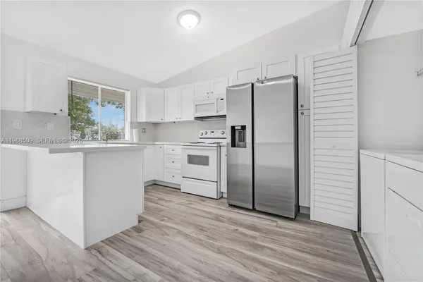 a kitchen with stainless steel appliances a refrigerator sink and microwave