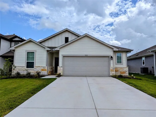 a front view of a house with a yard and garage