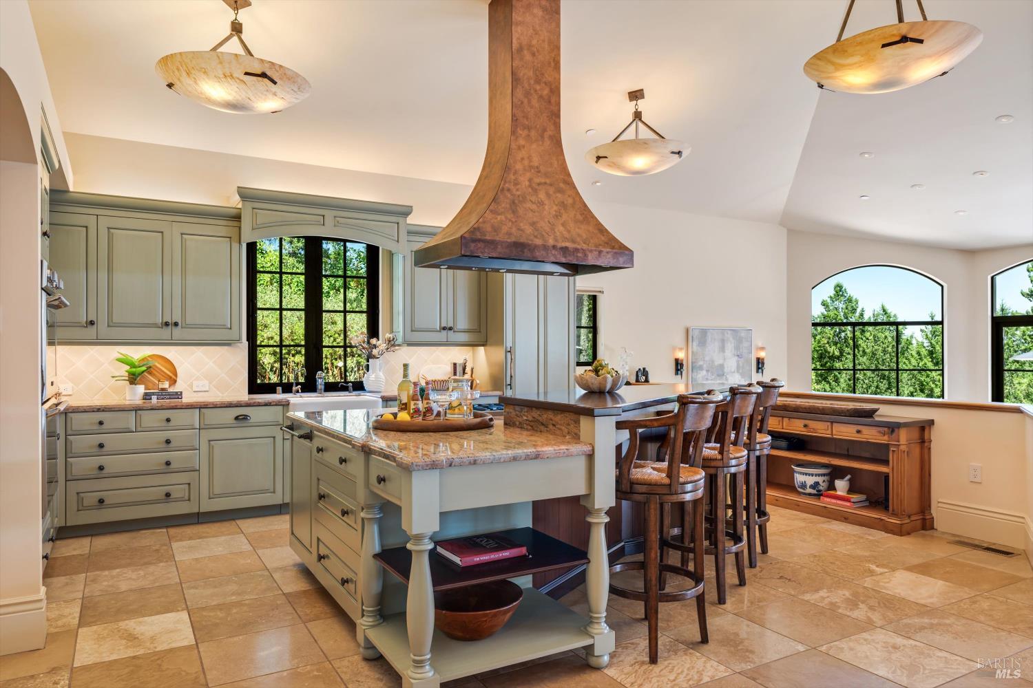 1315 West Dry Creek Road Healdsburg, CA 95448 - Photo 7 of 57 a kitchen with stainless steel appliances a stove a chimney a dining table and chairs