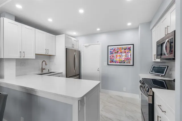 a kitchen with white cabinets and stainless steel appliances