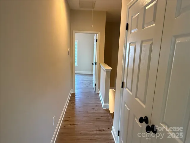 a view of a hallway with wooden floor and staircase