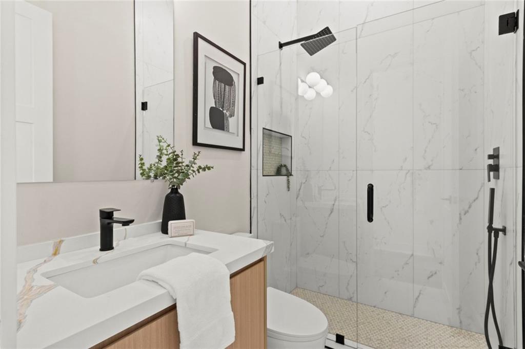 7066 Bells Way Fairburn, GA 30213 - Photo 16 of 64 a bathroom with a sink a toilet and shower