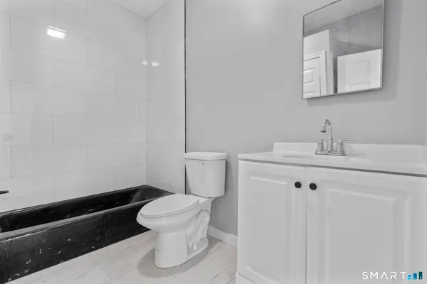 a bathroom with a sink a toilet and a mirror