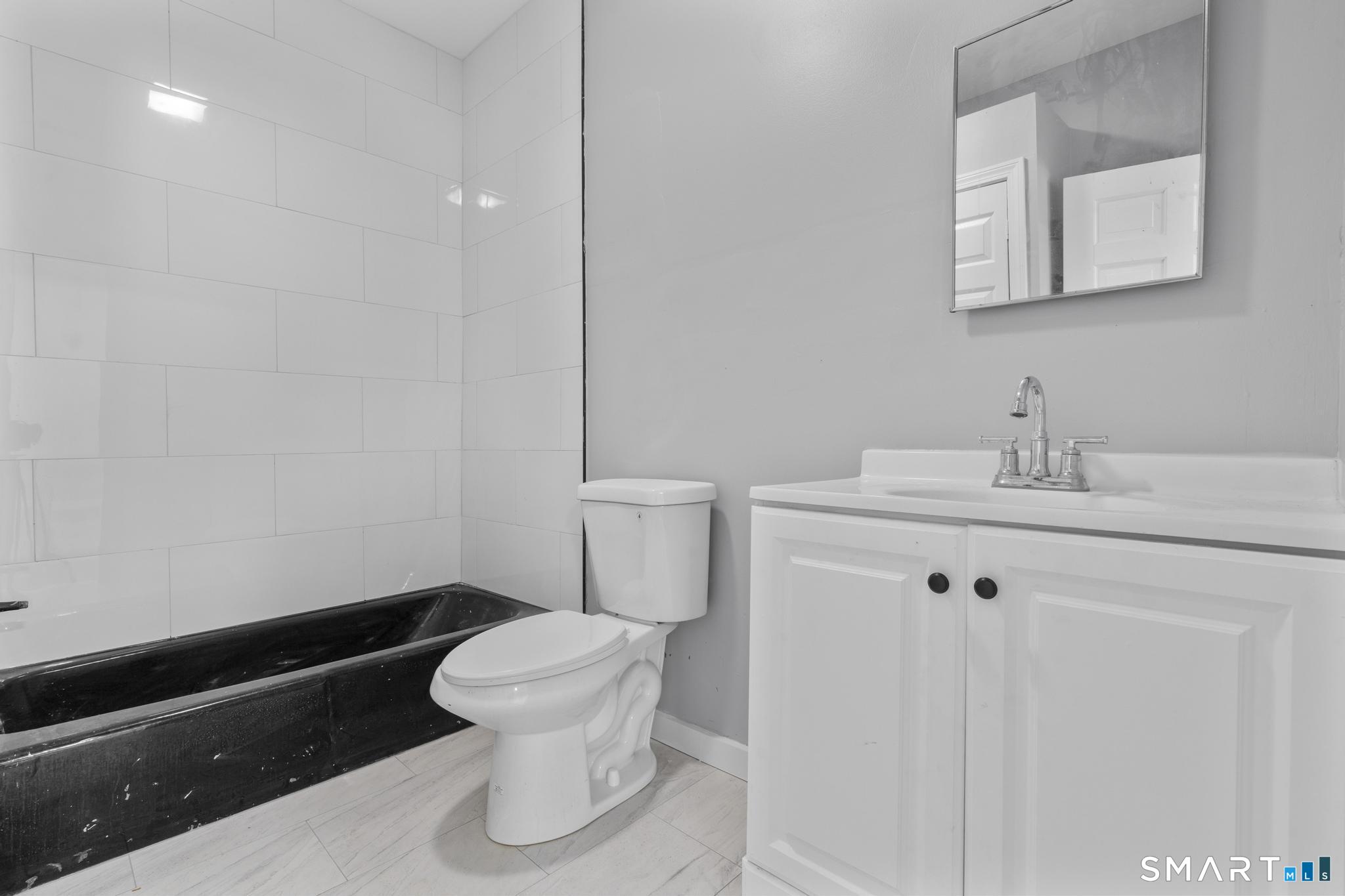 257 North State Street Ansonia, CT 06401 - Photo 14 of 36 a bathroom with a sink a toilet and a mirror