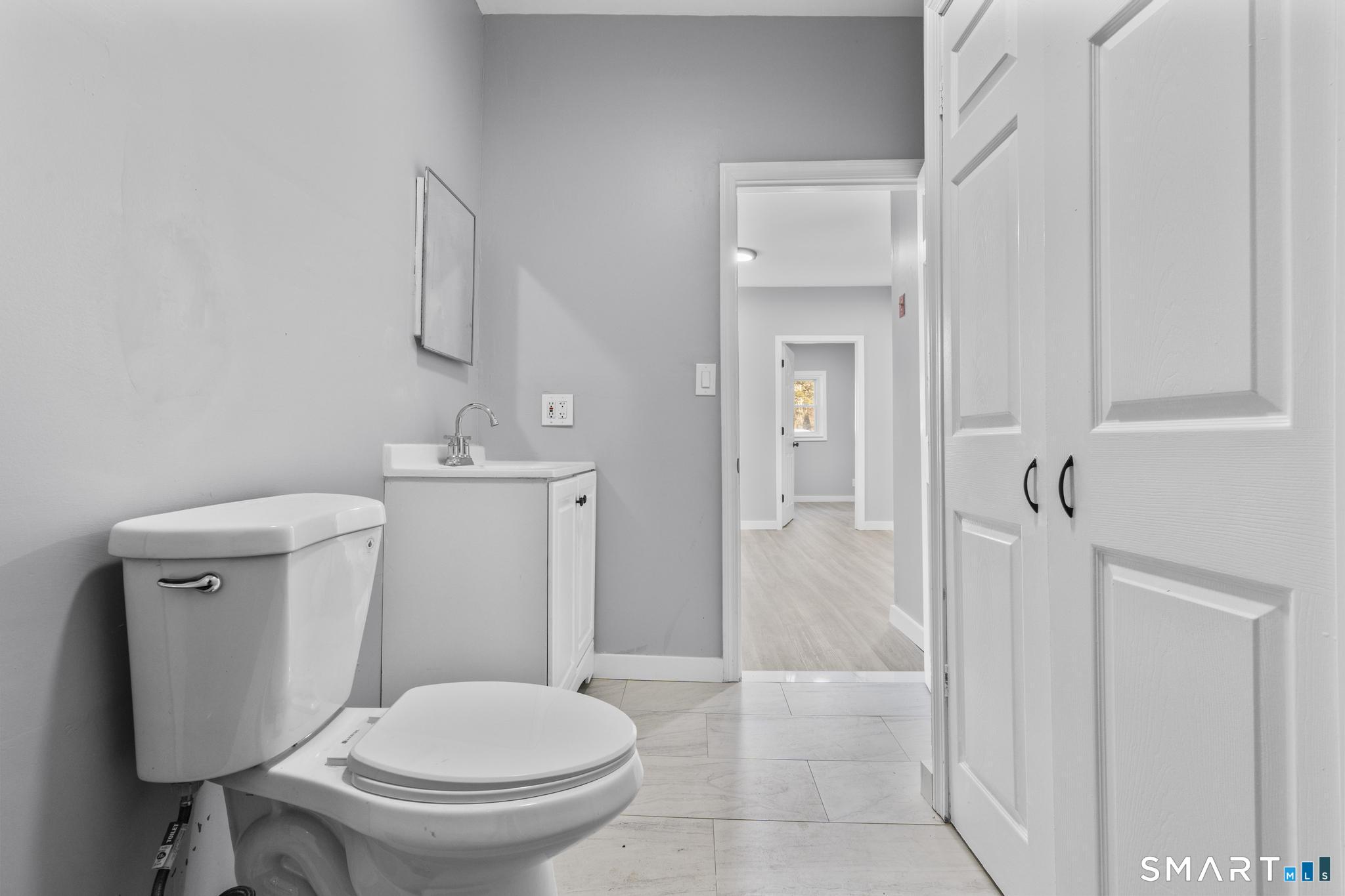 257 North State Street Ansonia, CT 06401 - Photo 15 of 36 a white toilet sitting next to a bathroom sink
