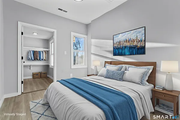 a bedroom with a bed and a painting on the wall