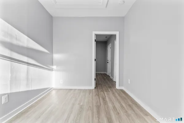 a view of a hallway with wooden floor and a window