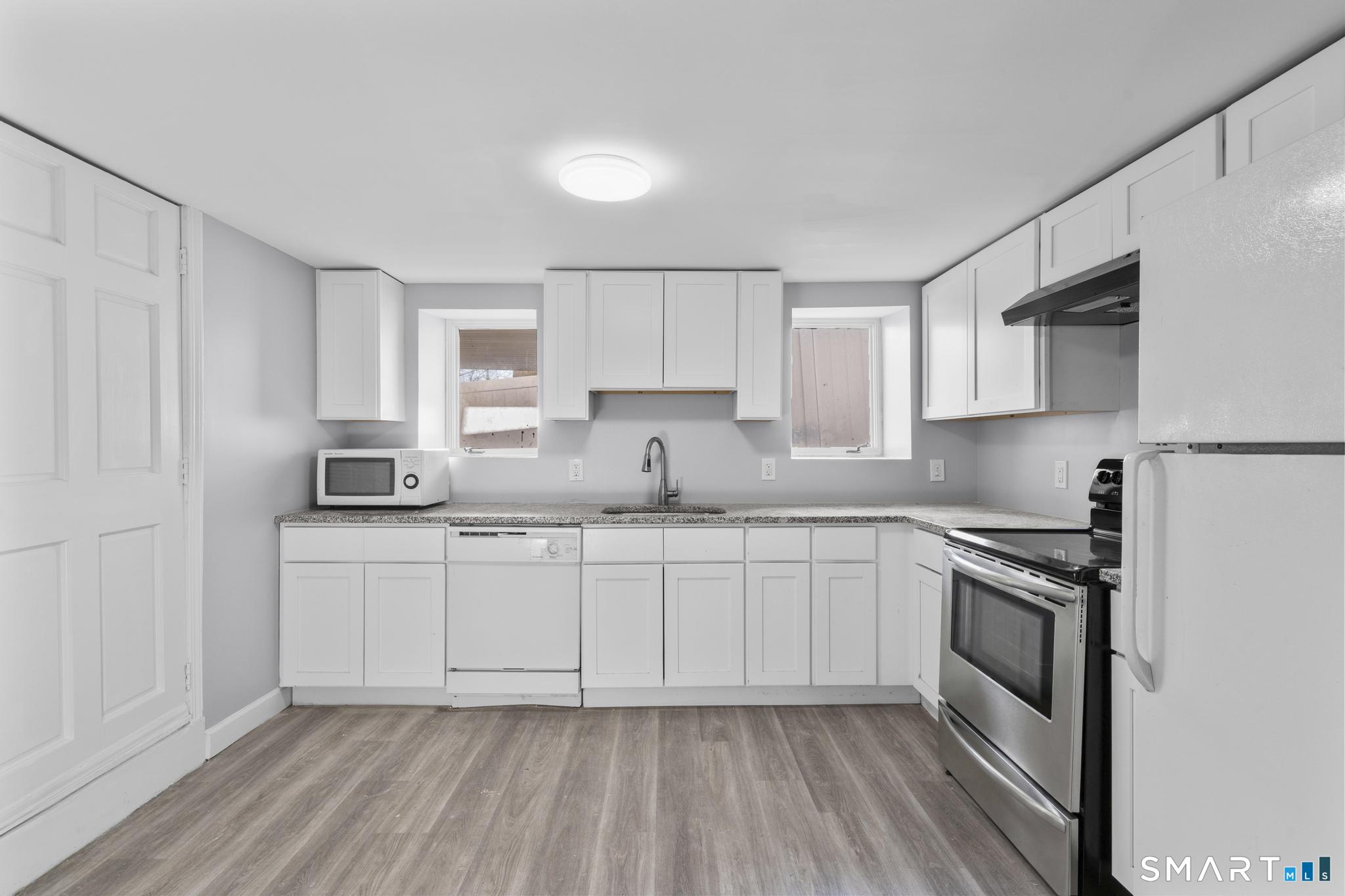 257 North State Street Ansonia, CT 06401 - Photo 23 of 36 a kitchen with granite countertop white cabinets and white appliances