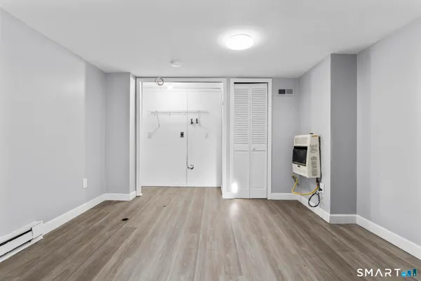 a view of empty room with wooden floor