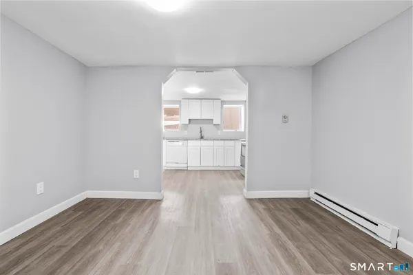 a view of a room with wooden floor and white walls