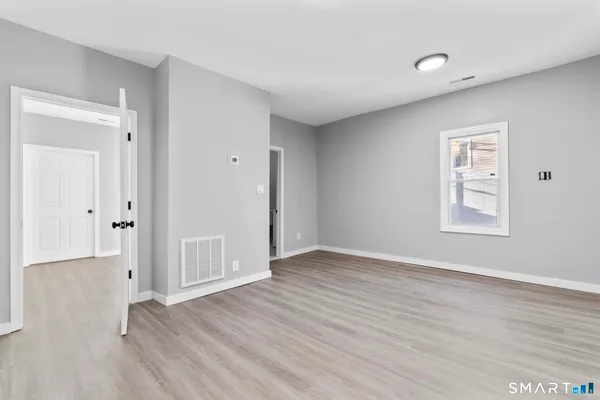 a view of an empty room with wooden floor