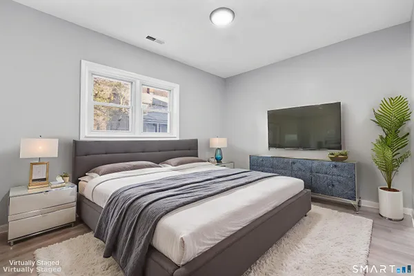 a bedroom with a bed and a flat screen tv