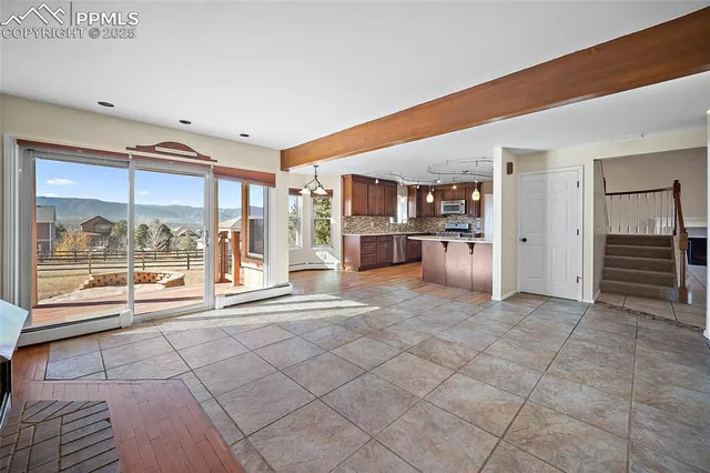 a view of empty room with a kitchen