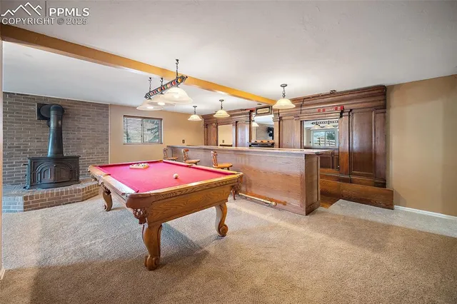 a dining hall with stainless steel appliances granite countertop a dining table chairs and a refrigerator