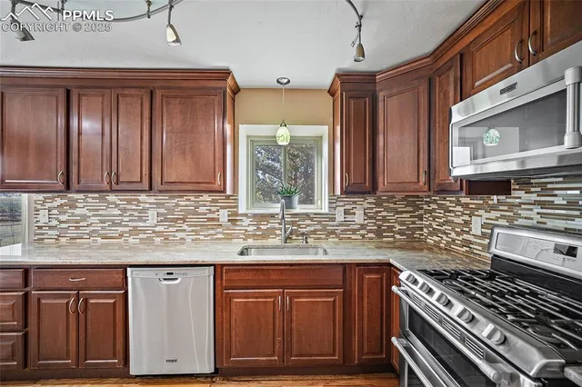 a kitchen with granite countertop a sink stove and cabinets
