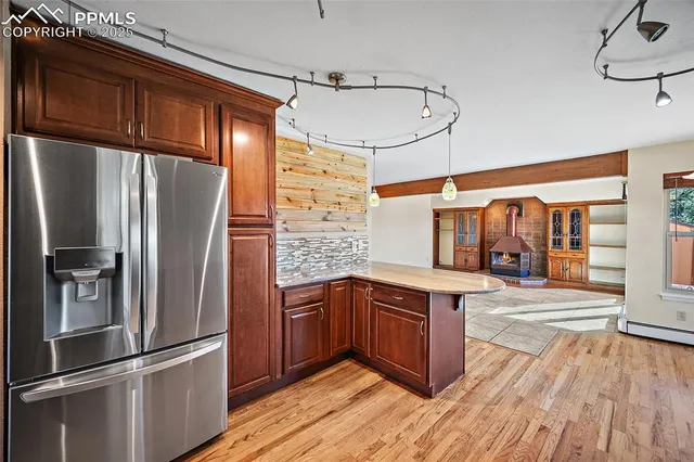 a kitchen with stainless steel appliances a refrigerator and wooden floor