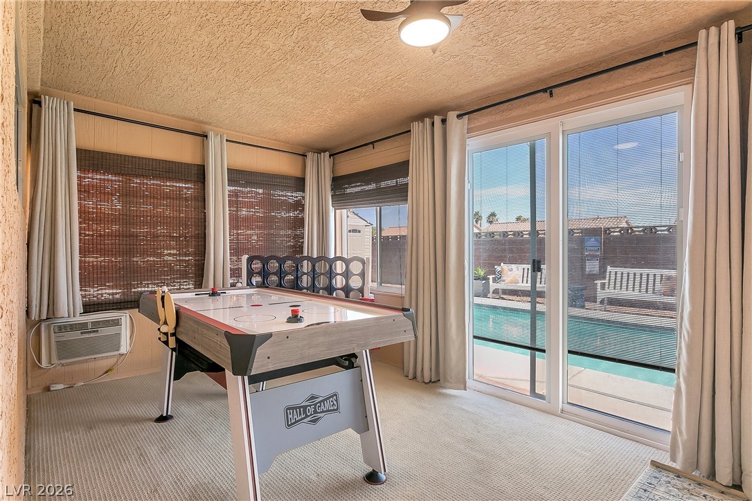 101 Beaver Ridge Avenue North Las Vegas, NV 89031 - Photo 28 of 42 A vibrant game room with large sliding doors opens to an inviting pool, perfect for leisure and recreation.