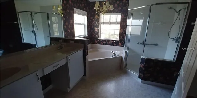 a bathroom with a granite countertop sink a mirror and shower