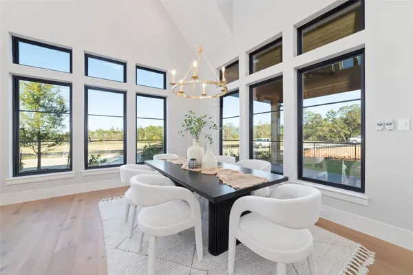 a dining room with furniture a chandelier and wooden floor