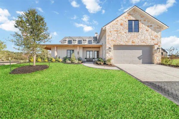 a front view of a house with a yard and trees