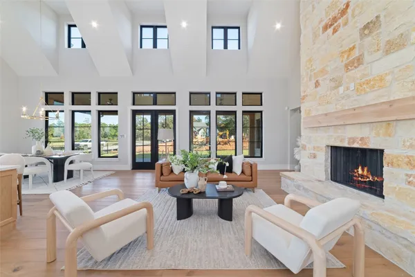 a living room with furniture large window and fireplace