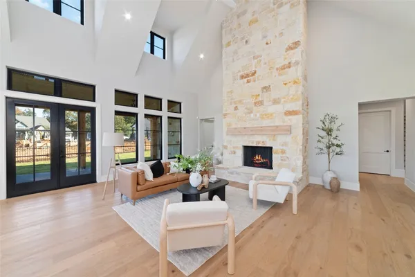 a living room with furniture large window and fireplace