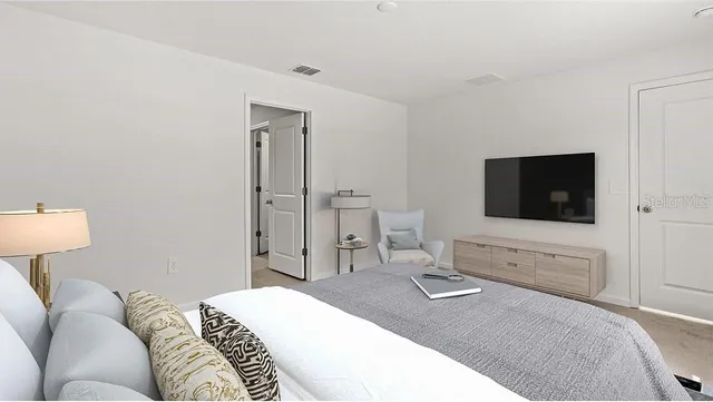 a bedroom with a bed and a flat screen tv