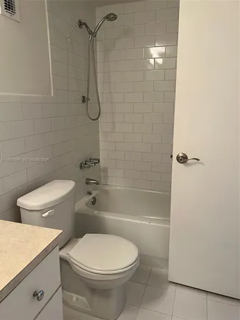 a white toilet sitting next to a bath tub and shower