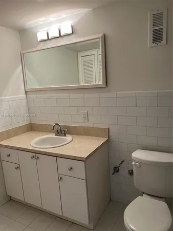 a bathroom with a toilet sink and mirror