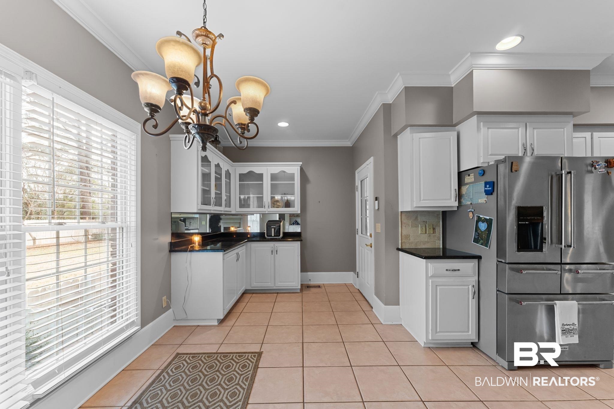 525 Norwood Road Monroeville, AL 36460 - Photo 14 of 55 Kitchen featuring stainless steel refrigerator with ice dispenser, white cabinetry, glass insert cabinets, backsplash, and light tile patterned flooring