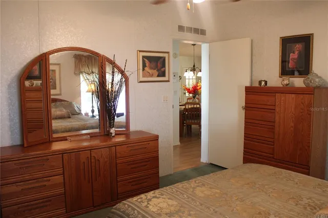a bedroom with a bed and a mirror on dresser