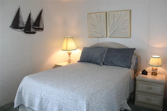 a bedroom with a bed and painting on the wall