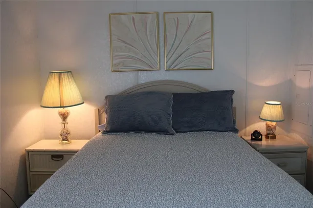 a bedroom with a bed and a lamp on table