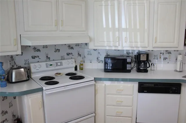 a kitchen with white cabinets and white appliances