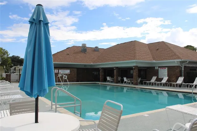 a front view of a house with a garden and lake view