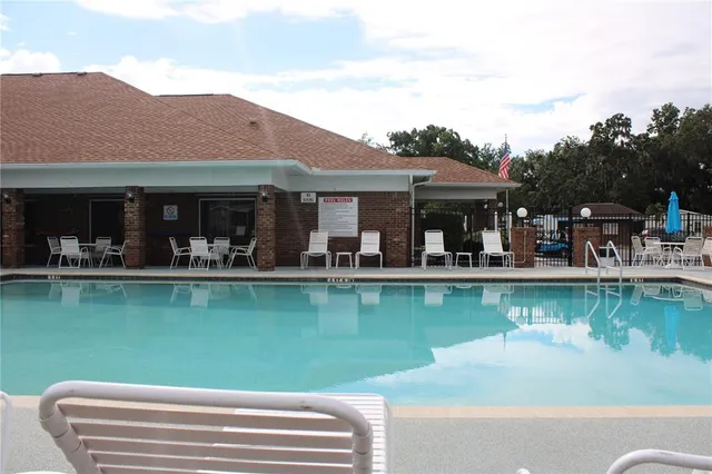 a view of a lake with a house swimming pool and outdoor seating