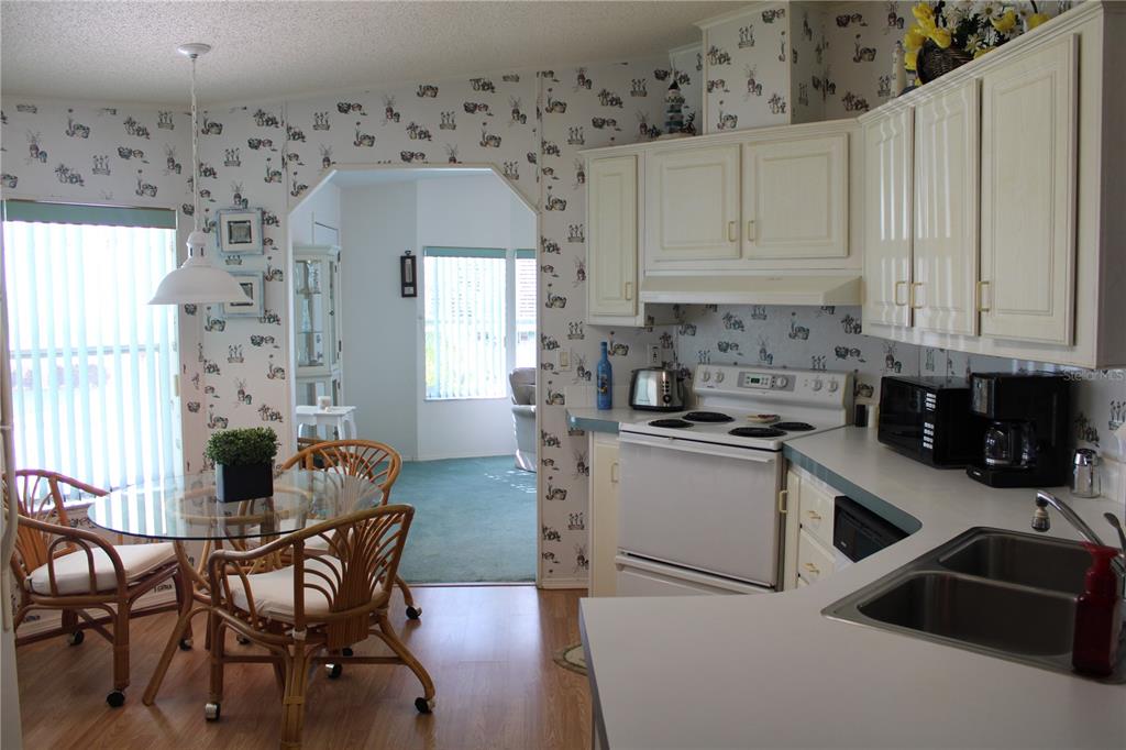 8314 Nancy Lane Ellenton, FL 34222 - Photo 3 of 34 a kitchen with stainless steel appliances a white table and chairs in it
