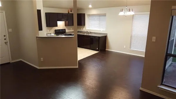 a kitchen with stainless steel appliances granite countertop a stove a sink and a wooden floor