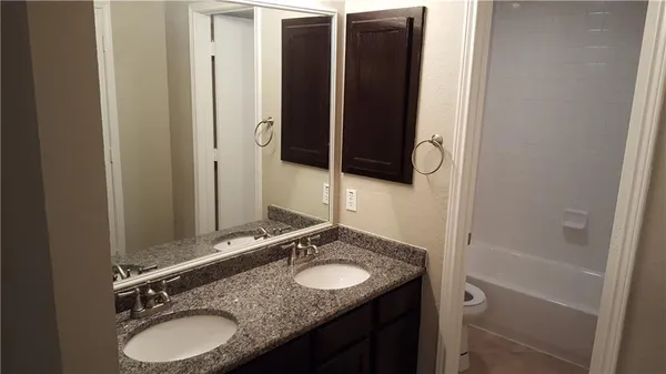 a bathroom with a granite countertop sink and a mirror