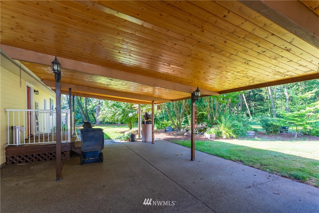 8949 Delta Line Road Custer, WA 98240 - Photo 19 of 39 a view of a patio with table and chairs under an umbrella with a large tree