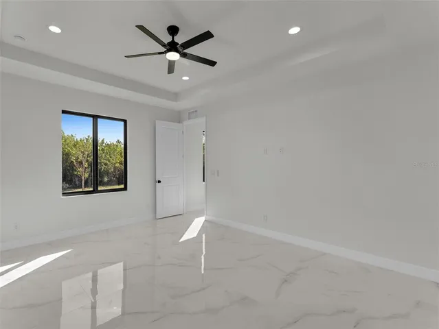 an empty room with a ceiling fan and window