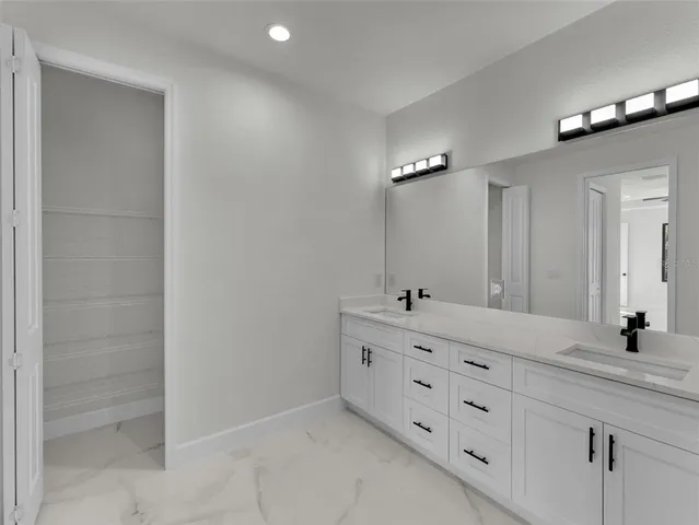 a bathroom with a double vanity sink a mirror and a bathtub