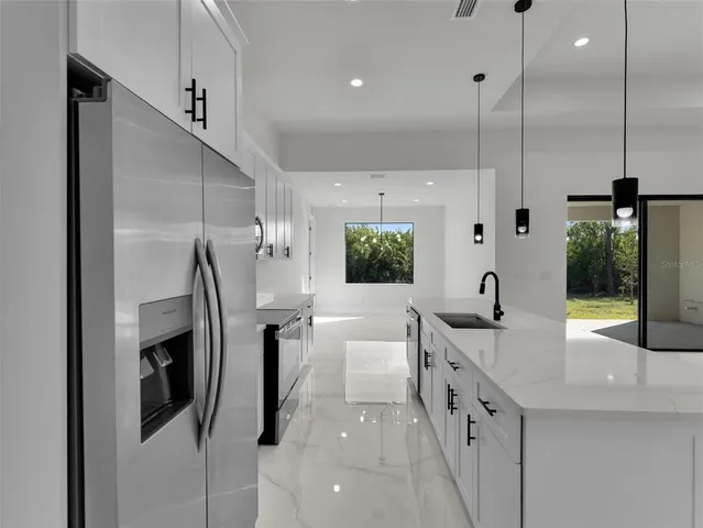 a kitchen with stainless steel appliances a refrigerator sink and wooden floor
