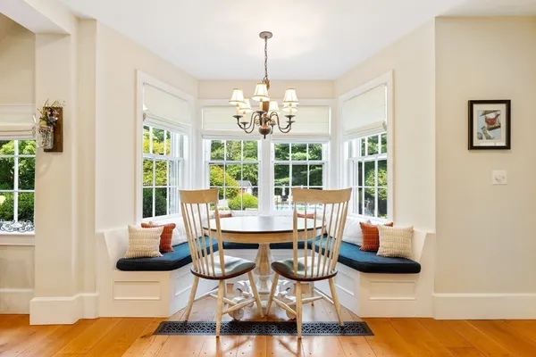 a dining room with furniture a chandelier and wooden floor