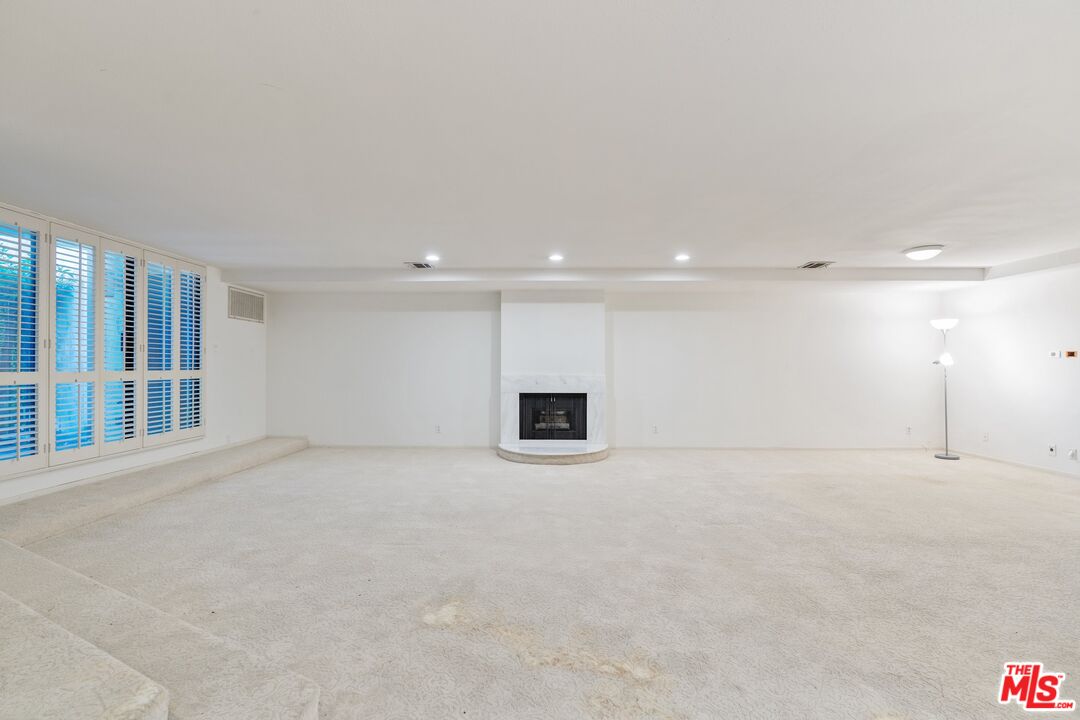 11687 Bellagio Road, Unit 5 Los Angeles, CA 90049 - Photo 7 of 31 a view of an empty room with a fireplace