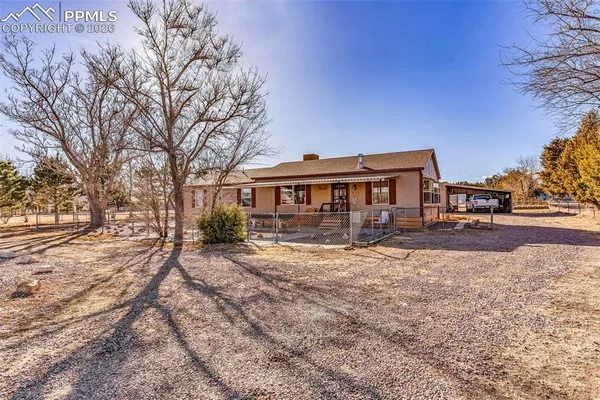 a front view of a house with yard and trees