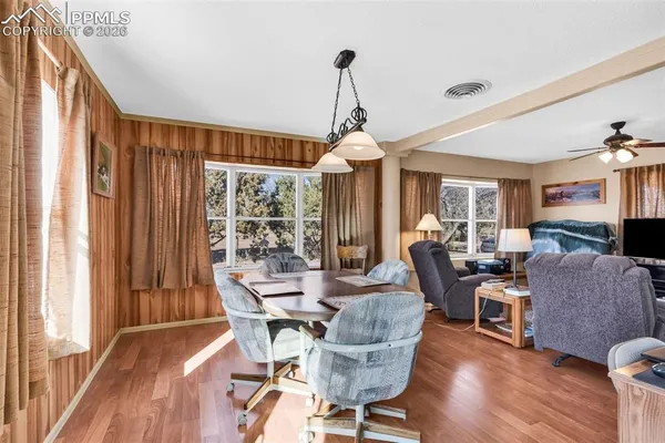 a dining room with wooden floor and furniture